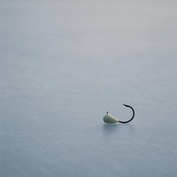 Small calm ice fishing rig lying quietly on blue ice