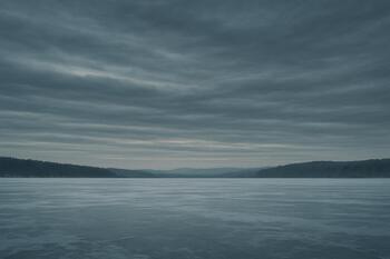 Layered winter clouds hanging above a frozen lake